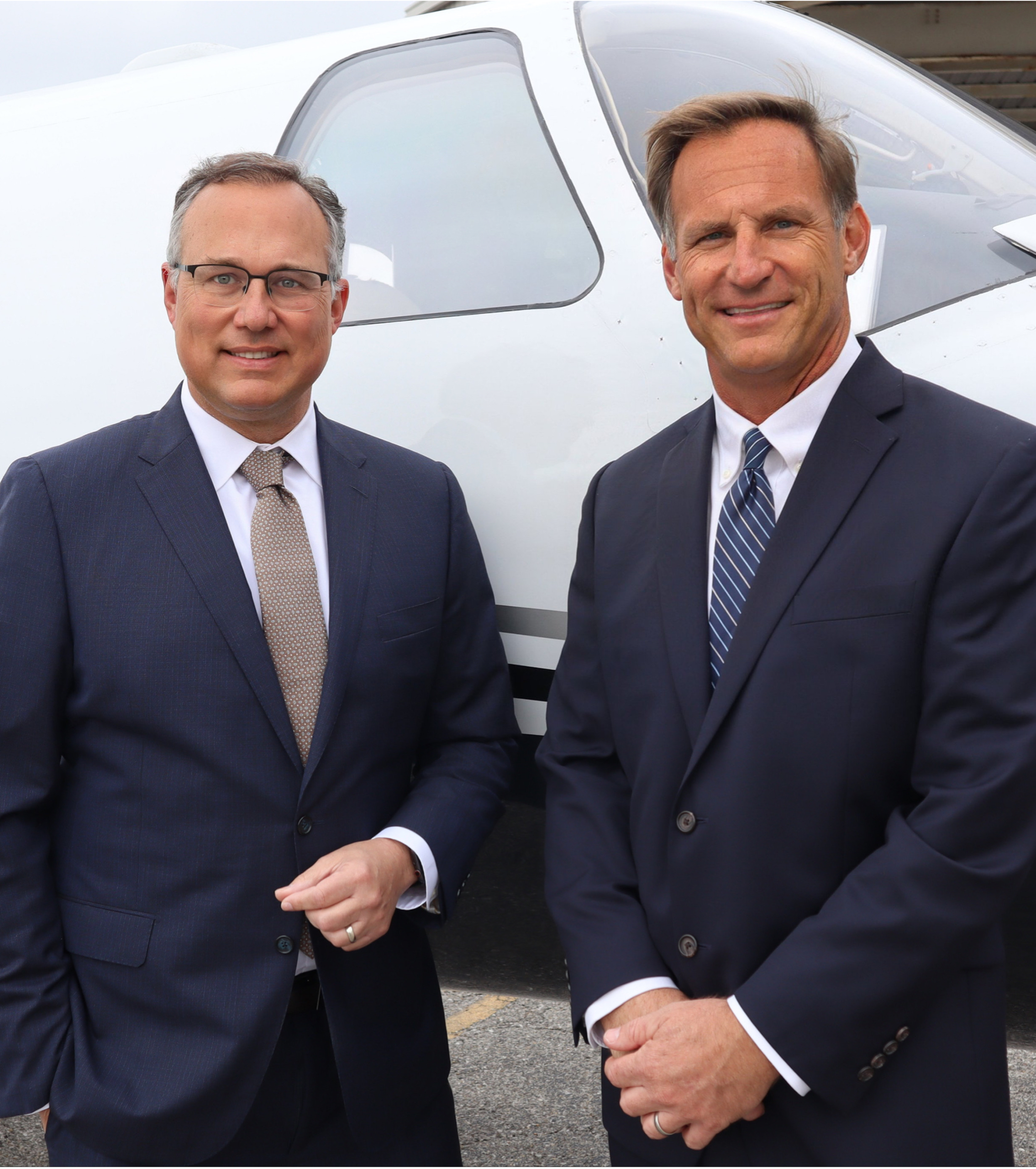 Picture of J.P. Dice (left) and Clay Sharpe (right) standing in front of a white plane